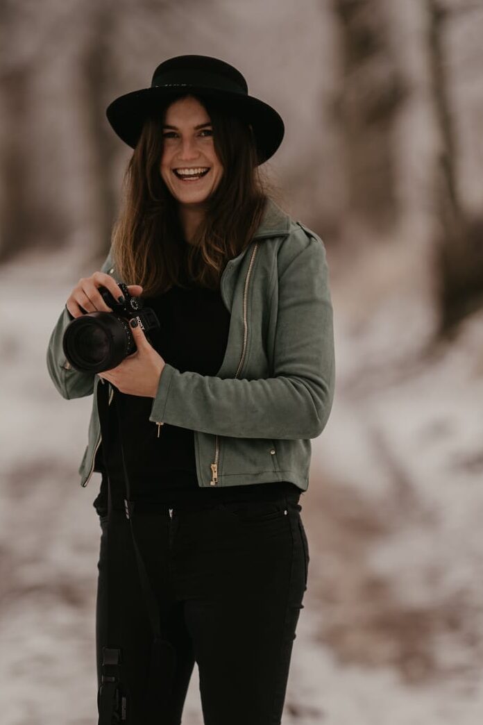 Fotografin in Grömitz hält Kamera und lächelt. 